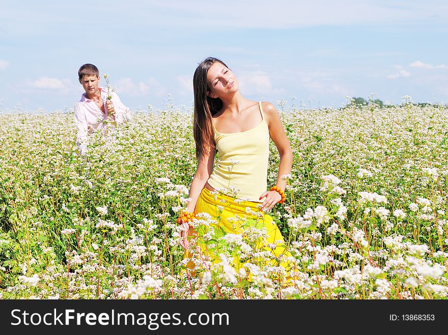 Young lovely couple in a spring field of flowers. Young lovely couple in a spring field of flowers
