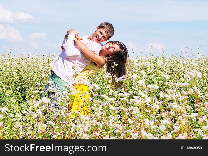 Young Lovely Couple On A Flower Field