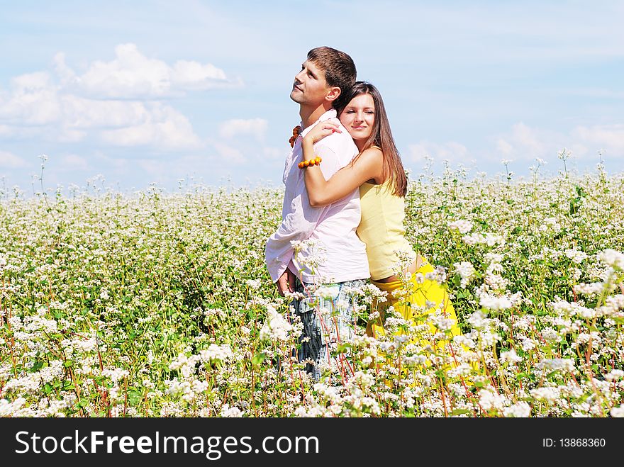 Young lovely couple in a spring field of flowers. Young lovely couple in a spring field of flowers