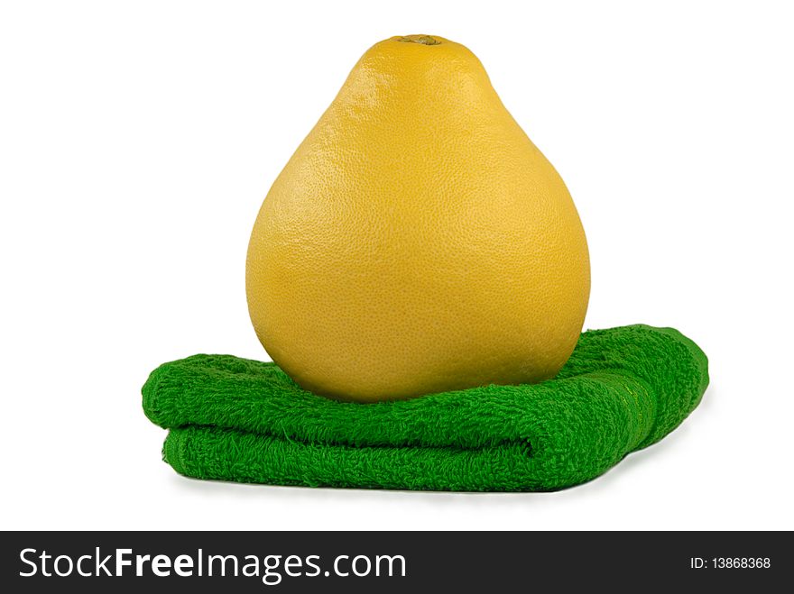 Fruit pomelo lies on green towel isolated in white