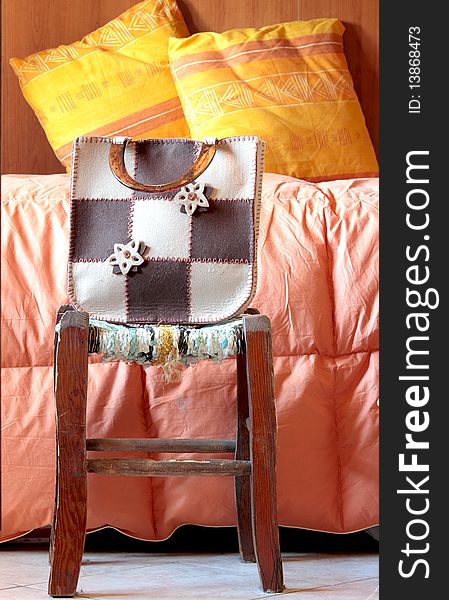 Bag leaning against a stool with a very retro background
