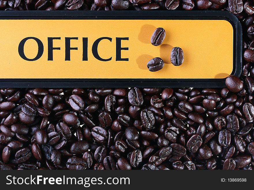 Coffee grains as a background on them the tablet with an inscription Office.