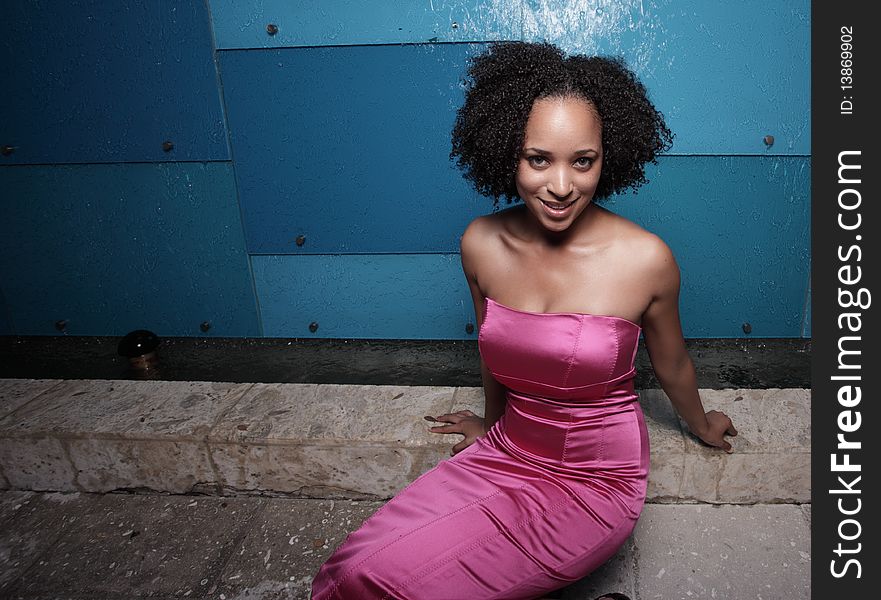 Attractive black woman sitting in a pink dress. Attractive black woman sitting in a pink dress