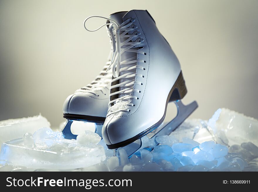 White figure skates on blocks of ice in the studio settings. White figure skates on blocks of ice in the studio settings