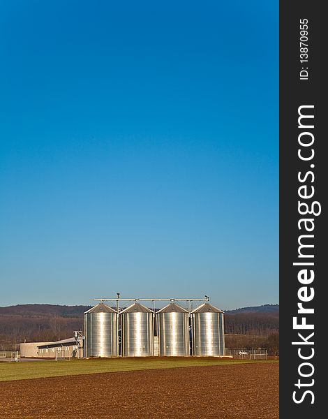 Beautiful landscape with silo and snow white acre with blue sky
