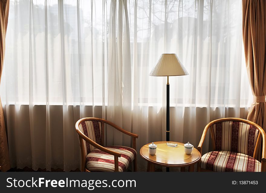 Two wood back rest chairs with cushion by the window,concept of intimate friends chatting.