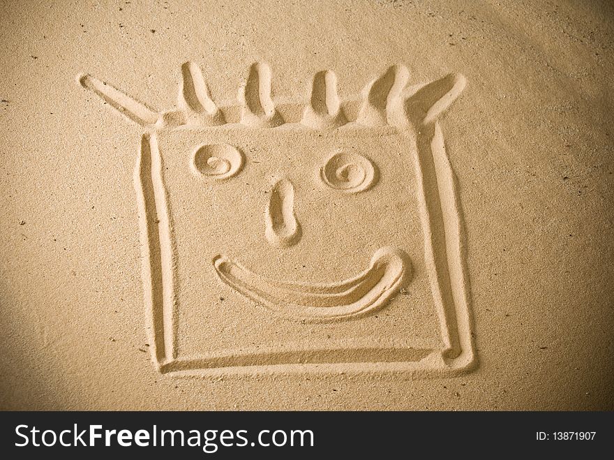 Smiling face handwritten on sand