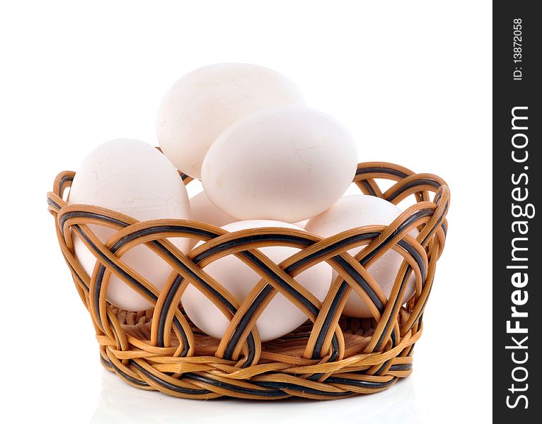 White eggs in a basket on white background