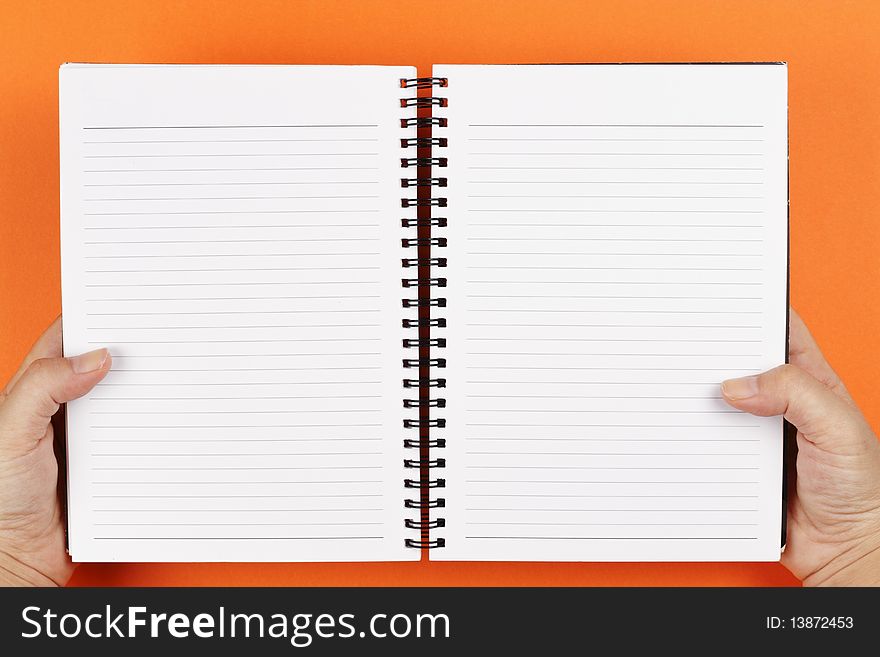 A pair of hands holding an open notebook. A pair of hands holding an open notebook