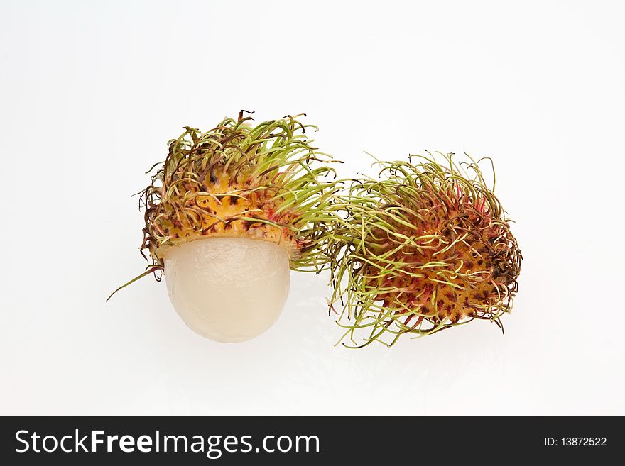 A halved rambutans against a white background