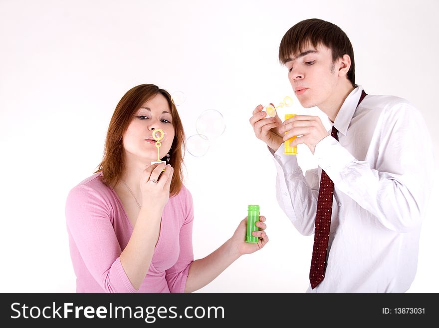 Romantic couple blowing soap bubbles In studio