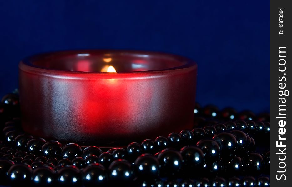 Red burning candle on a dark blue background
