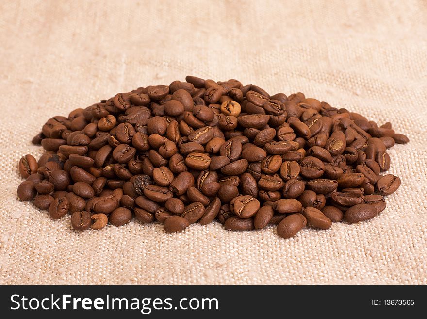 Heap of coffee beans on the rustic canvas