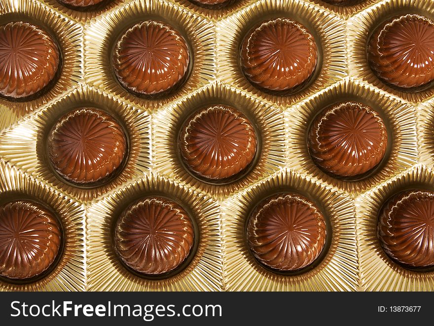 Box of chocolates inside. Dark chocolate in gold foil.