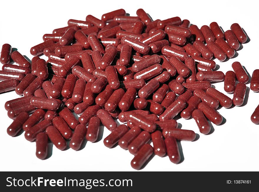 Red capsules on white bakground
