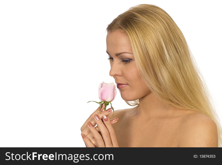 A beautiful woman breathing in the scent of a rose