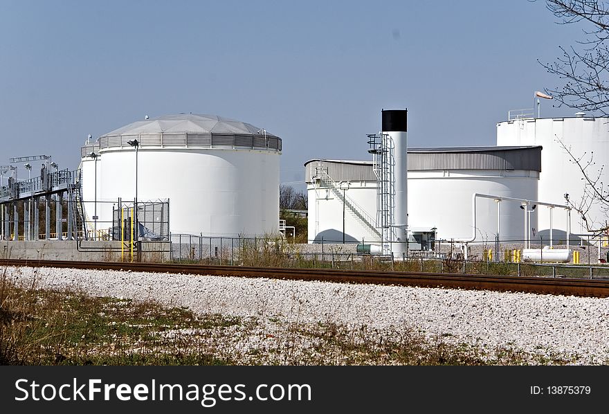 A group of fuel storage tanks on the outskirts of a busy city.