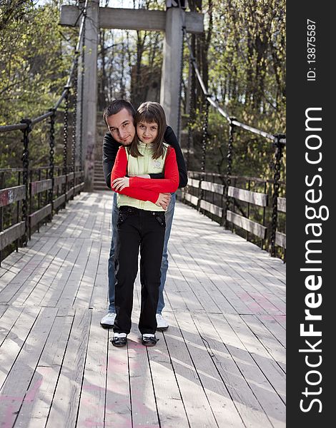 Couple of adult man and little girl on a bridge. Couple of adult man and little girl on a bridge