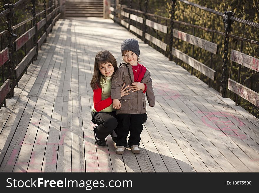 Couple of cute boy and girl on a bridge. Couple of cute boy and girl on a bridge