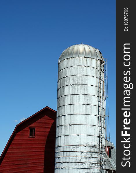 A Red barn and silo against blue sky