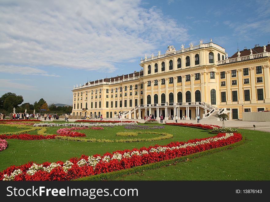 A corner view of magnificent Schoenbrunn Palace with three Primary colors - Red flowers, Green meadow and Blue sky. A corner view of magnificent Schoenbrunn Palace with three Primary colors - Red flowers, Green meadow and Blue sky