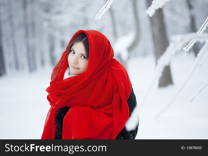 Beautiful girl in winter forest in red