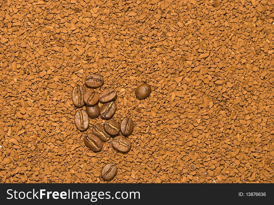 Coffee beans lies on instant coffee background
