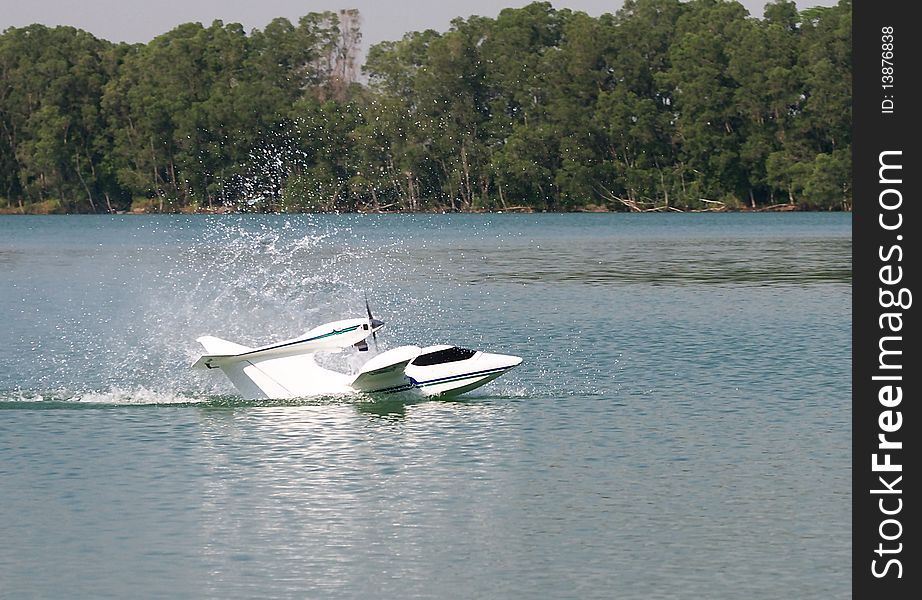 Remote control seaplane splashing-in, creating an impression on calm water. Remote control seaplane splashing-in, creating an impression on calm water.