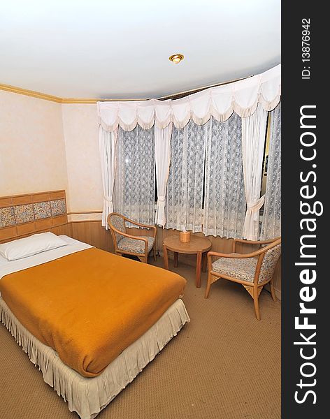 Single bed in hotel room with furniture