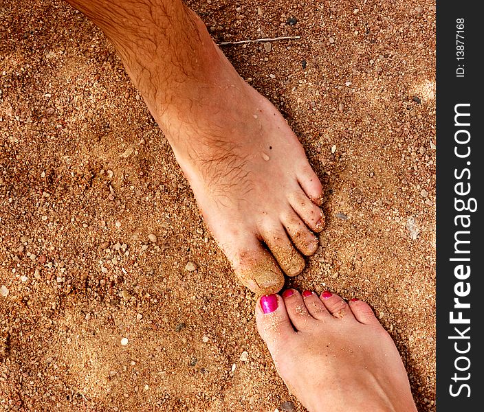 Man and woman feet on sandy beach. Man and woman feet on sandy beach