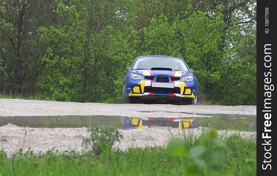 Blue race rally car on dirt road competition