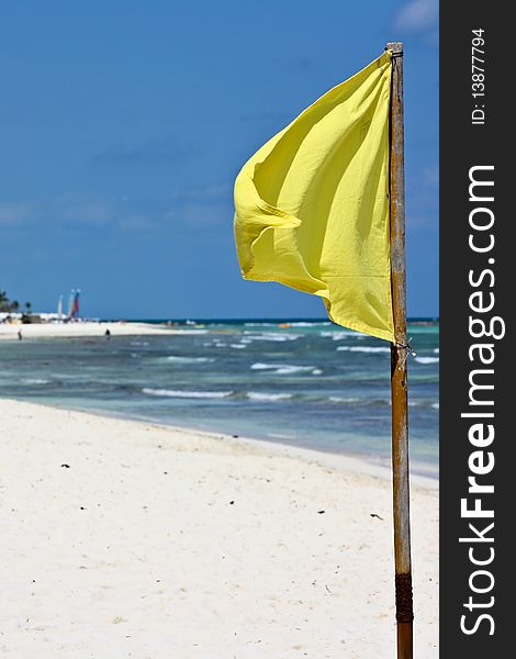 Yellow flag on white sand beach in tropics. Yellow flag on white sand beach in tropics