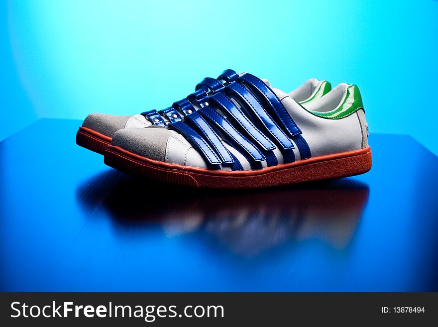 Cool funky designer sneakers with blue lit background