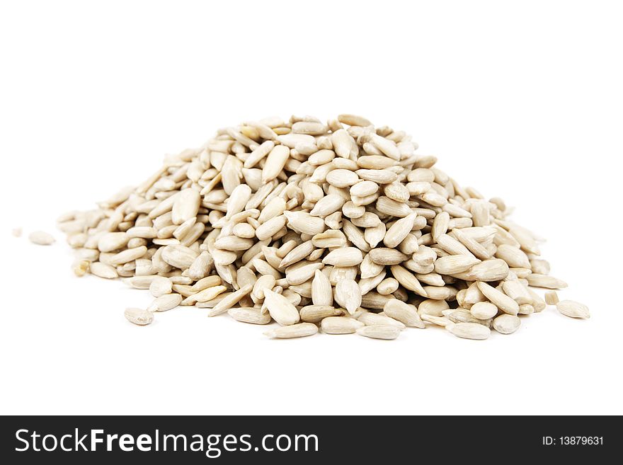 Pile of sunflower seeds on a reflective white background