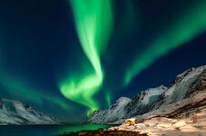 Amazing Aurora Borealis In North Norway Kvaloya, Mountains In The Background Stock Photo