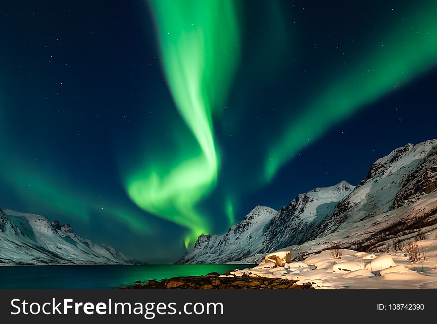 Amazing Aurora Borealis in North Norway Kvaloya, mountains in the background