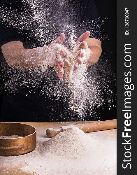 Closeup of hands of a woman who juggles to sift flour for the dough preparation. Closeup of hands of a woman who juggles to sift flour for the dough preparation