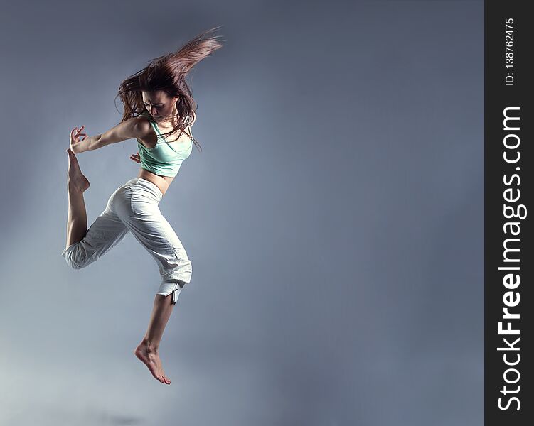 Beauty girl dance on grey background. person jumping, flying in the air