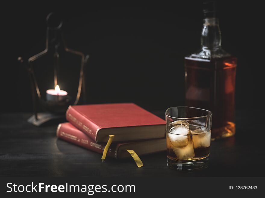 A glass of whiskey and a good book - time to relax - photo in retro style