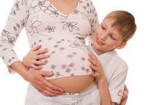 Son With Surprise Hugs Belly Of Pregnant Mother Stock Photography