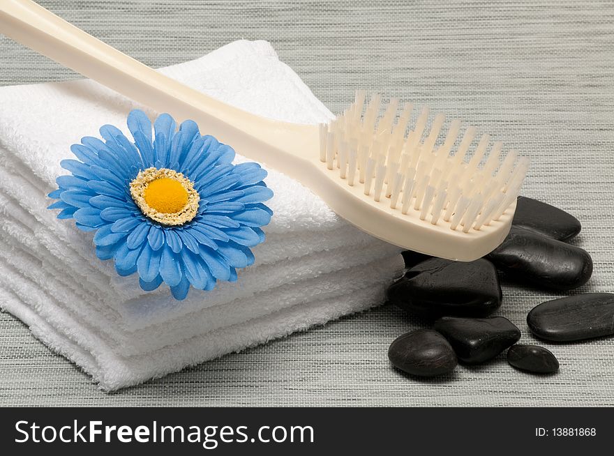 Bath back brush, towels, rocks and blue gerber daisy. Bath back brush, towels, rocks and blue gerber daisy
