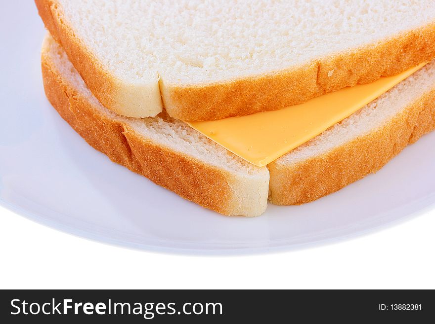 On a plate two slices of bread, between them cheese.