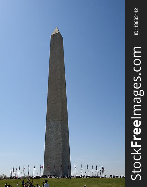 Washington monument on sunny day with flags