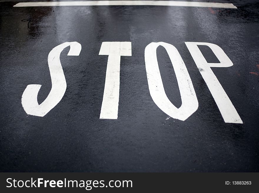 Stop road sign on the wet pavement