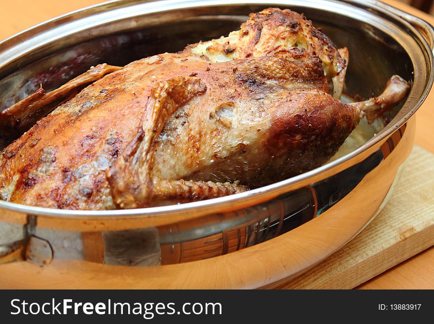 Roasted duck in pan on the wooden desk