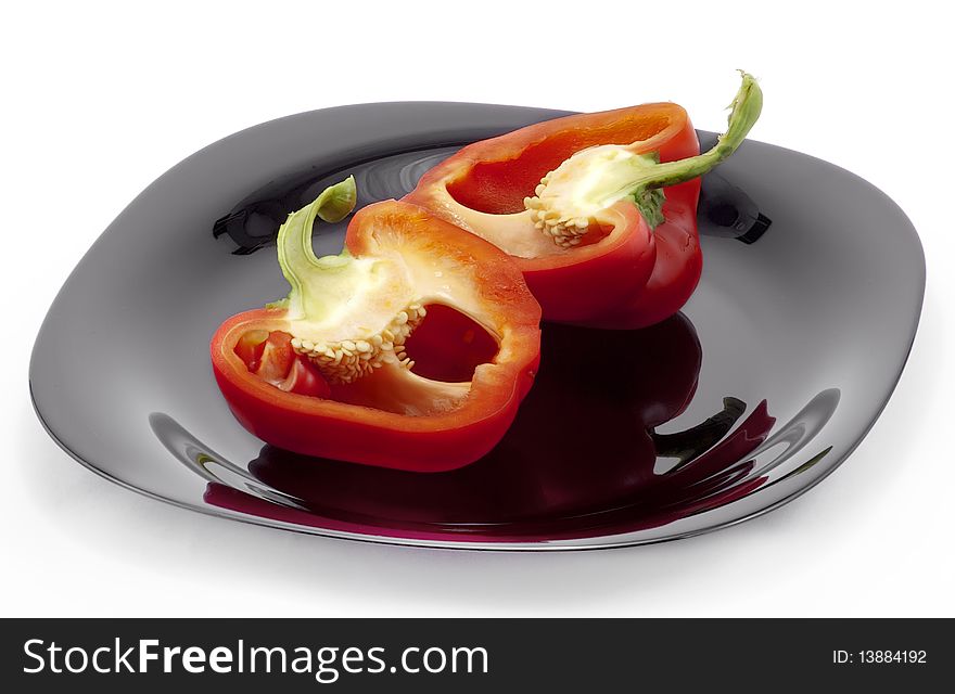 Sliced red pepper on the black plate. Sliced red pepper on the black plate
