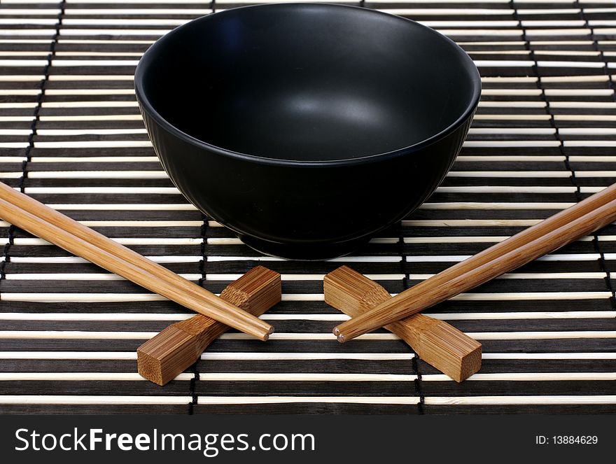 Black bowl and wooden chopsticks for sushi. Black bowl and wooden chopsticks for sushi