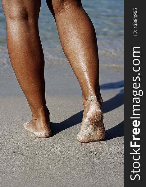 Tanned womans´s legs on the beach. Tanned womans´s legs on the beach