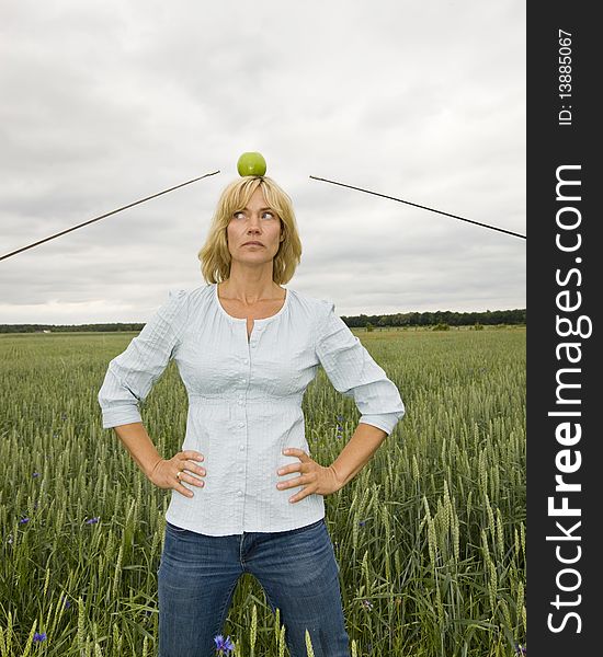 Woman as Wilhelm Tell in a field between two duelling people. Woman as Wilhelm Tell in a field between two duelling people.