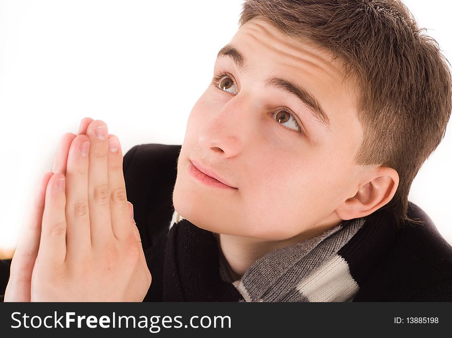 Handsome young man praying on a white background